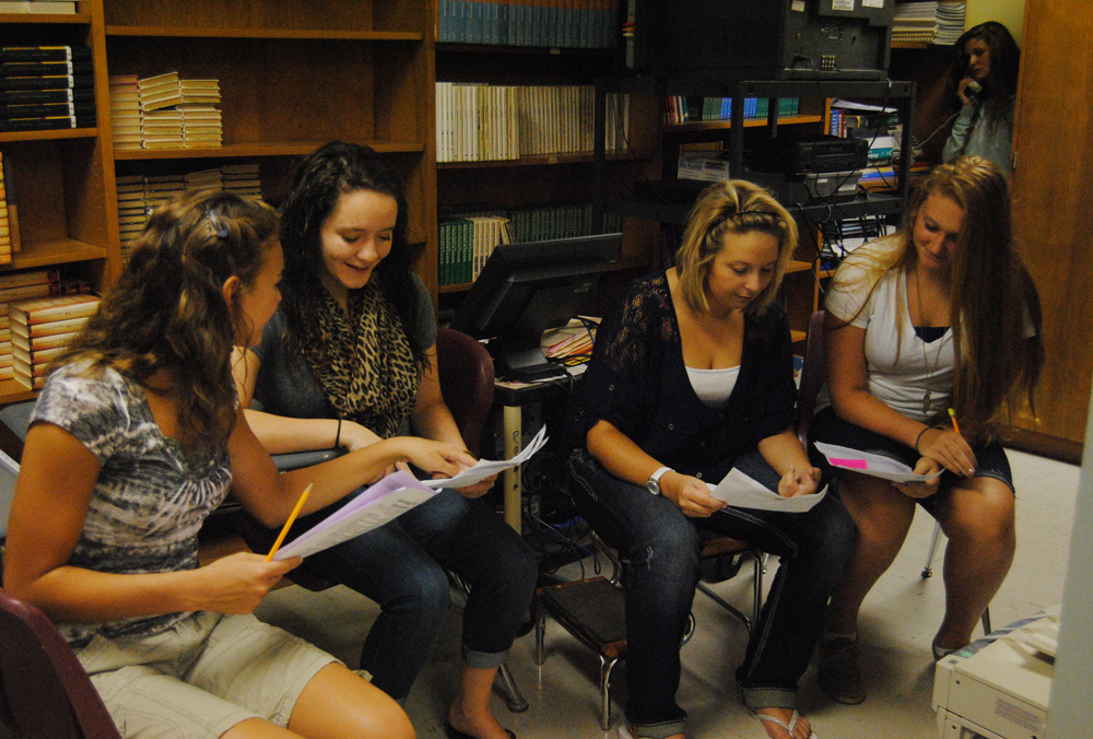 Junior Brandie Hankins teaches new yearbook staff members Freshmen Claire Cornwell, Jaylin Busick and Hannah Sanders how to sell ads during Ad Sales Week. 